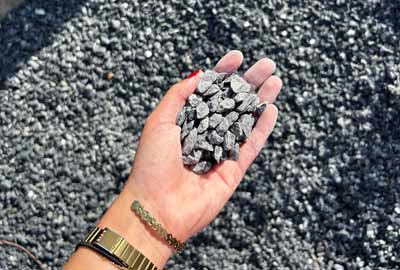 photo de gravier noir de calibre 6/10 concassé dans une main